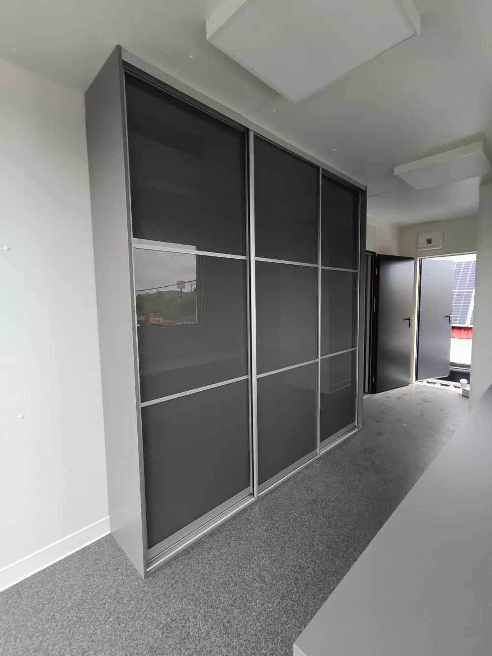 Vstavaná skriňa s posuvnými dverami v kombinácii zrkadla a dreveného dekoru do chodby